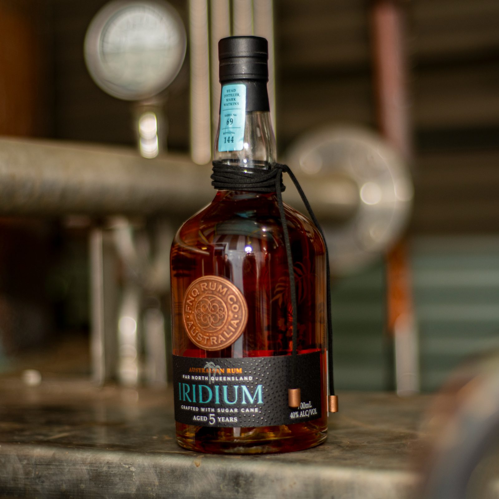 Bottles of Iridium standing against the copper pot still