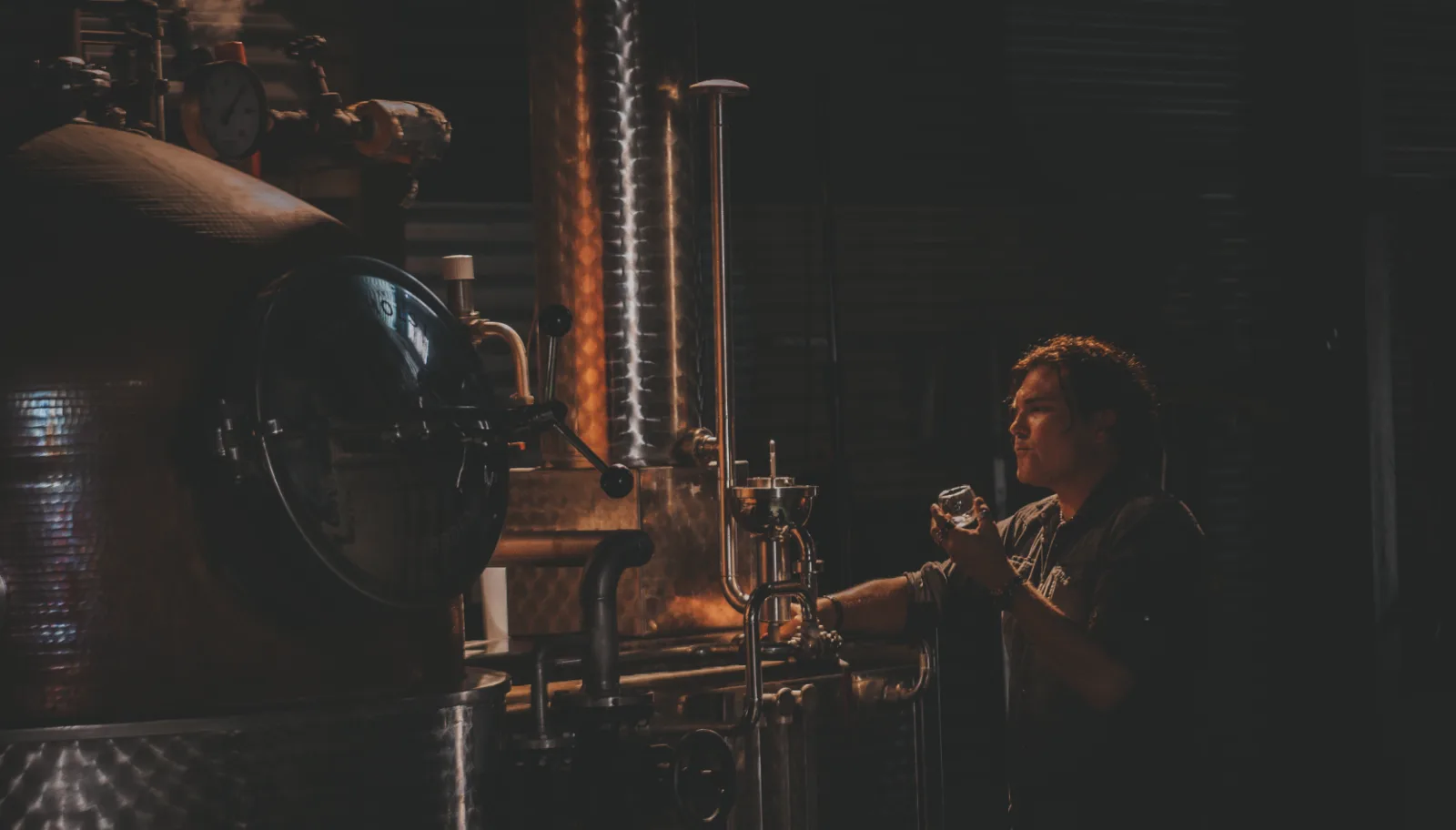 Distiller nosing spirit drawn from the spirit safe during the run