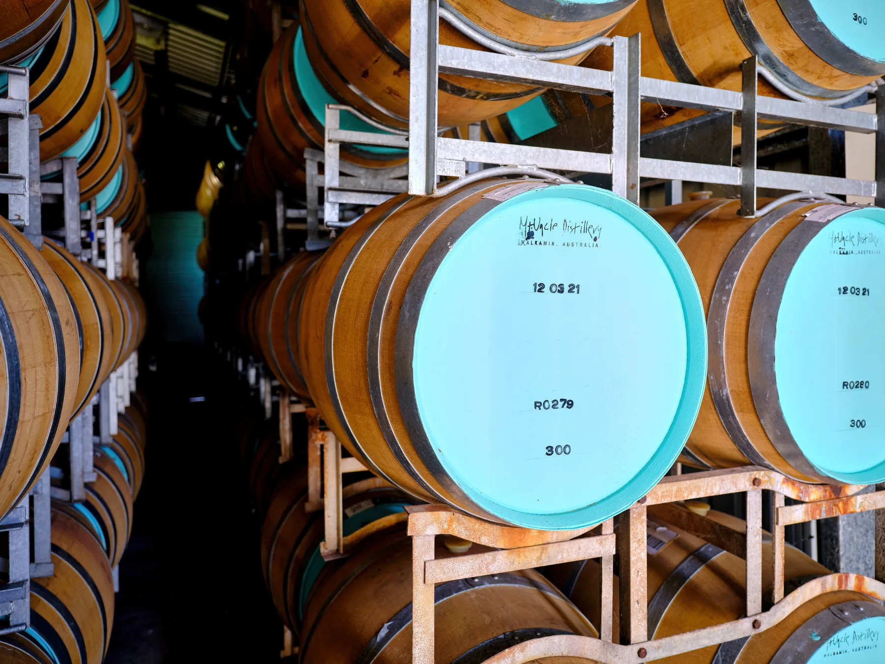 Casks racked and marked with fill dates in the barrel room at Walkamin