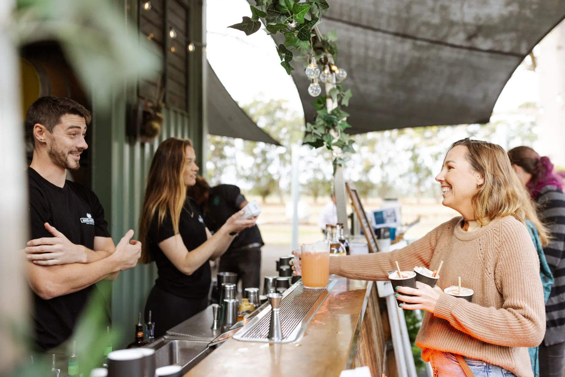 Staff serving guests at the cellar door bar at Mt Uncle Distillery